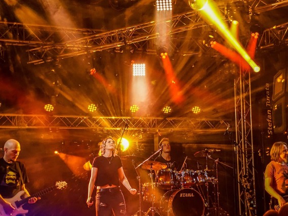 Eine vom Lichtspiel geflutete Bühne mit Musikern darauf