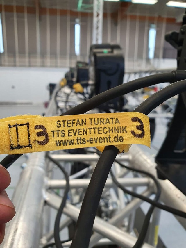 Eine Nahaufnahme eines Etiketts mit der Aufschrift "Stefan Turata, TTS Eventtechnik, www.tts-event.de"
